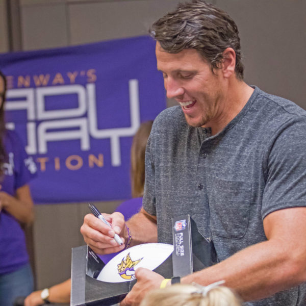 Chad Greenway signs a football at the LifeSource Team MN-DAK fundraiser